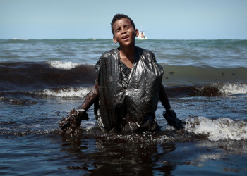 Foto de menino coberto de óleo viraliza e traduz a tragédia do litoral nordestino